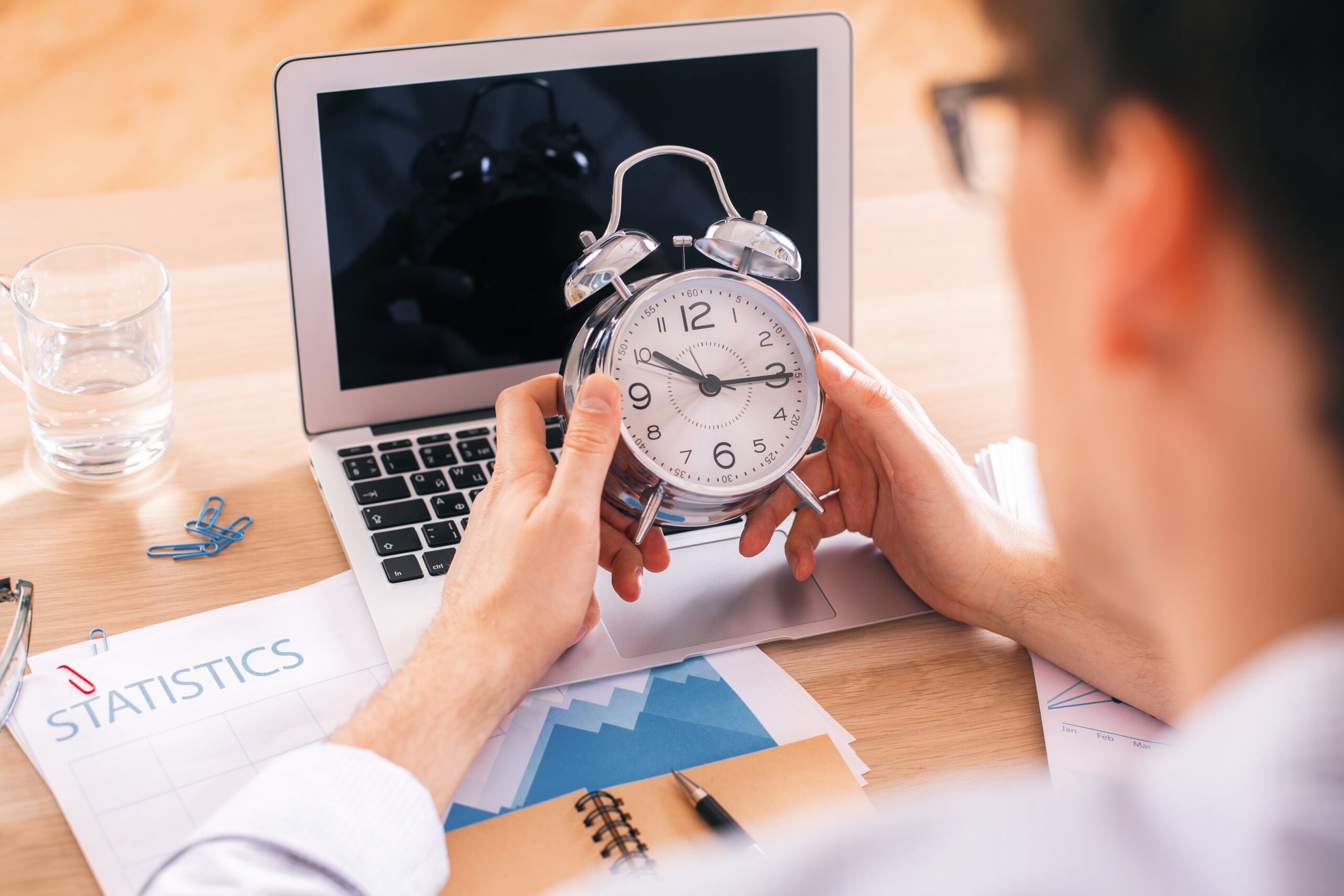 Importance of Time Tracking: A male holding an alarm clock, symbolizing the crucial role of time management and tracking in business success